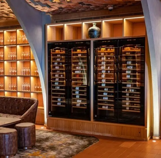 Mur de caves à vins professionnelles de service EuroCave encastrées dans restaurant. Scénographie et design intérieur. Mise en scène de l'offre vin.