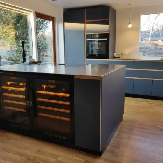 Combinaison de caves à vin encastrables EuroCave compact installées dans un ilot de cuisine. Conservation optimale, portes totalement vitrée, éclairage intégré, clayettes coulissantes.