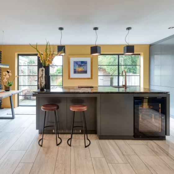 Petite cave à vin EuroCave Inspiration encastrée dans un ilôt de cuisine. Lumière intégrée, conservation optimale des bouteilles de vin.